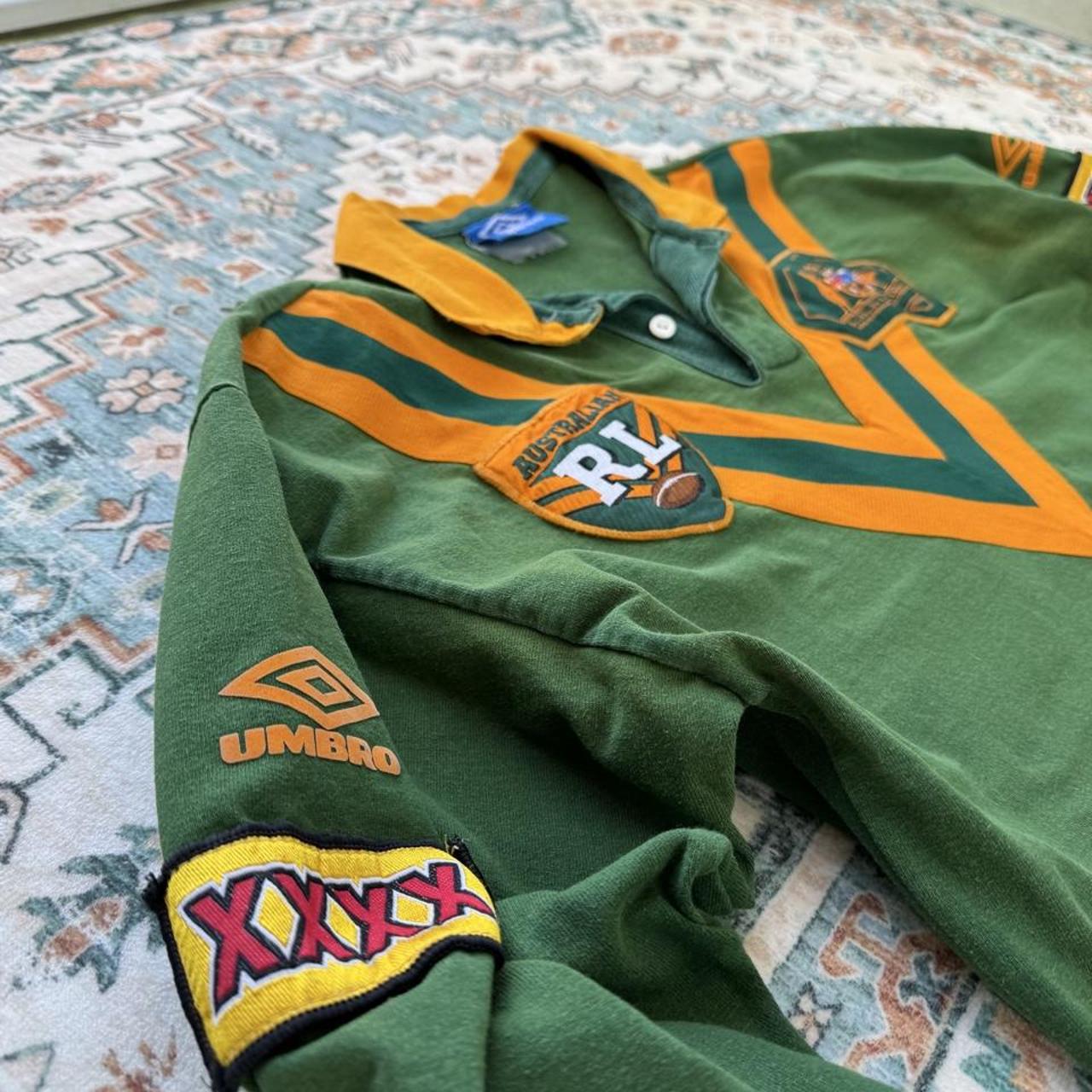 Umbro men's polo shirt green with Wallabies logo and rugby league pattern.
