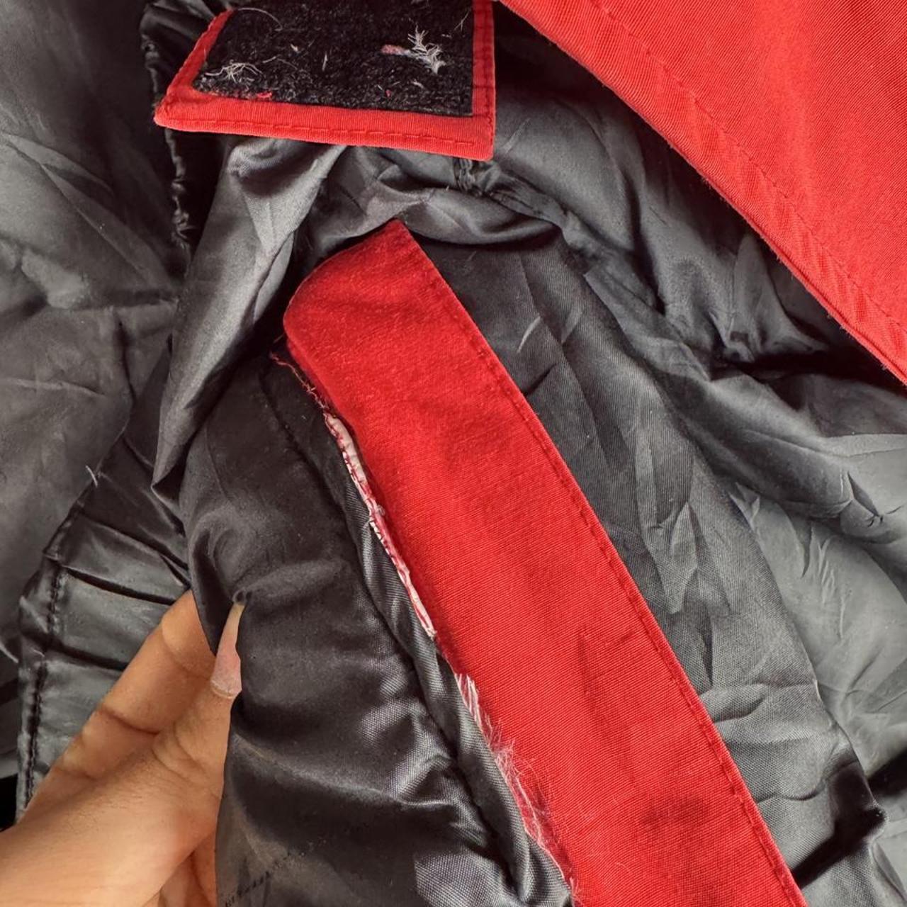 Canada Goose red parka jacket with logo patch and thick insulated material.