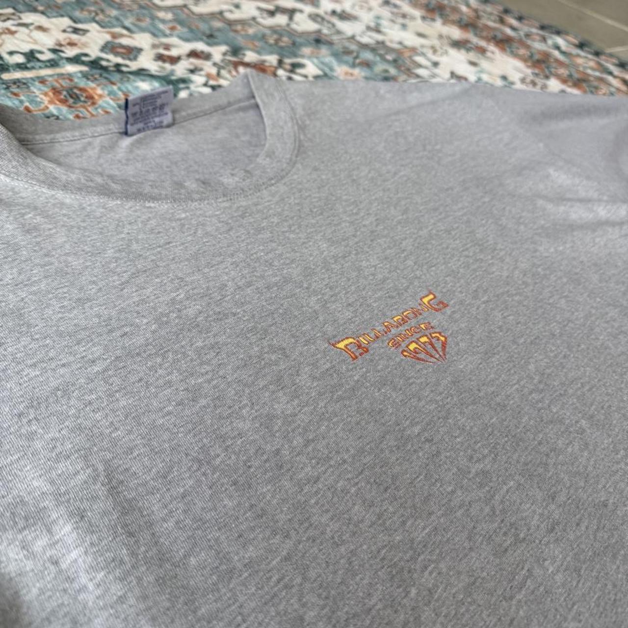Billabong oversized graphic t-shirt blue with cream and green patterns, featuring pocket detail.