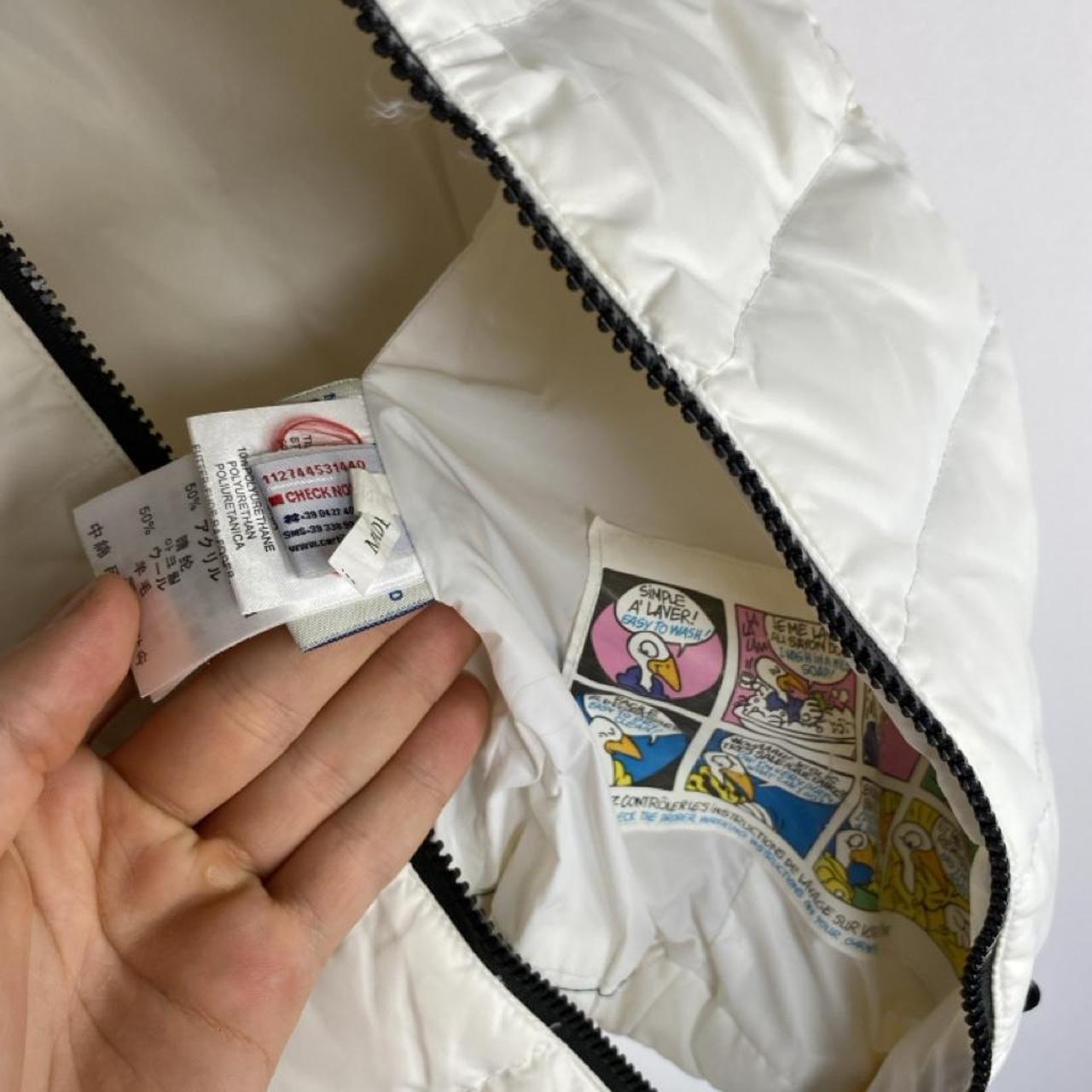 Moncler white down puffer gilet with logo detail and missing belt.