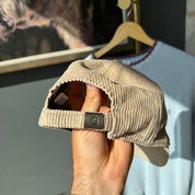 Carhartt WIP cream corduroy cap with embroidered logo detail.